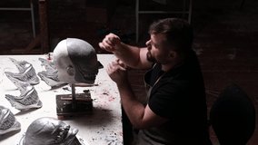 Artisan craftsman modeling mask based on plaster cast. Gypsum mold and plastic mask sculpting. - Powered by Shutterstock - Get 15% off with code: PIKWIZARD15