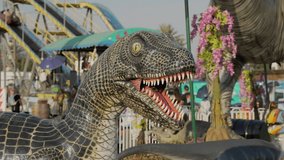 Los Angeles, CA USA - July 25 2022: This video shows a dinosaur display with a county fair in the background.