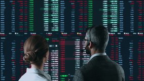 Colleagues traders are working with computer. Screen with stock charts and data analysis. Broker trading online. Concept of bitcoin BTC and stock market or crypto trading - Powered by Shutterstock - Get 15% off with code: PIKWIZARD15