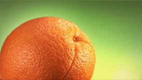 fresh orange fruit squirting with juice in slow motion video
