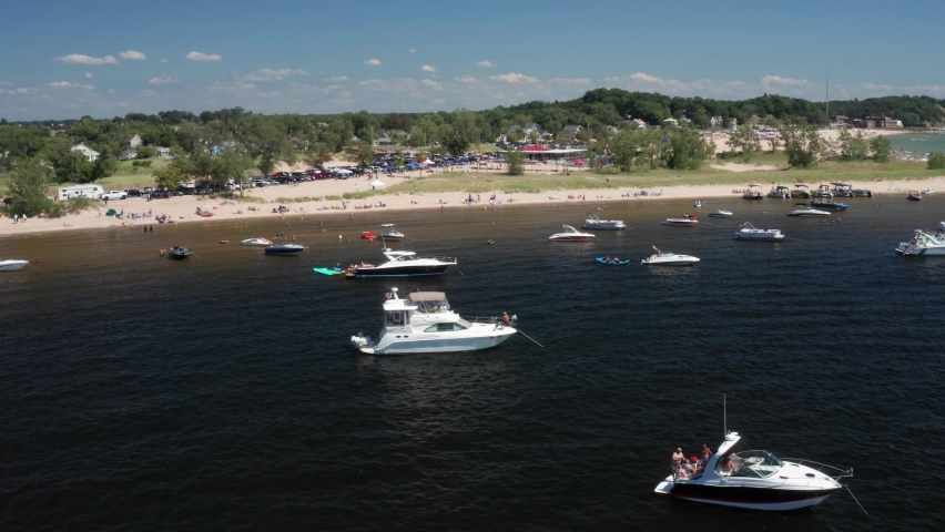 Boats in Lake Michigan in Muskegon, Michigan with drone video moving forward.