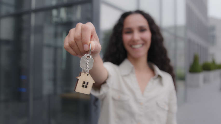 Happy smiling woman holding keys closeup portrait outdoors. Female realtor real estate agent lady selling property new building office dwelling skyscrapers girl homeowner rejoice relocation moving | Shutterstock HD Video #1093249891