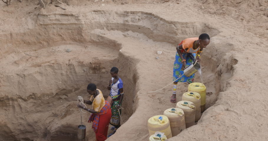 Climate change.drought.water crisis.Close-up.African woman collecting water in plastic containers from very deep wells due to persistent drought. Kenya Royalty-Free Stock Footage #1093252321