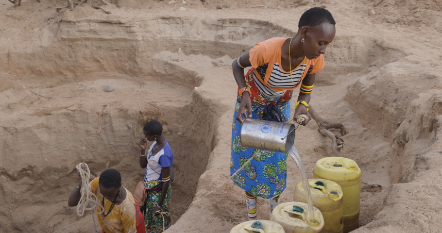 Climate change.drought.water crisis.Close-up.African woman collecting water in plastic containers from very deep wells due to persistent drought. Kenya | Shutterstock HD Video #1093252323