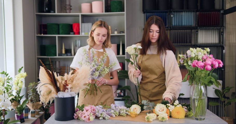 Two professional florist entrepreneur, take care of beautiful flowers, collect a bouquet. Women florists owners of a small business working together in own flower shop. Royalty-Free Stock Footage #1093252531