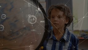 Animation of network of connections with icons over caucasian boy with globe at school. learning geography, education, connections and technology concept digitally generated video.