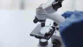 4k video footage of an attractive scientist using a microscope while working inside a laboratory.