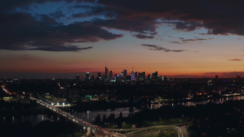 Stunning sunset skyline, aerial view panorama of Warsaw, Poland. Drone shot modern city downtown business center skyscrapers in background. Beautiful cloudscape evening dusk night