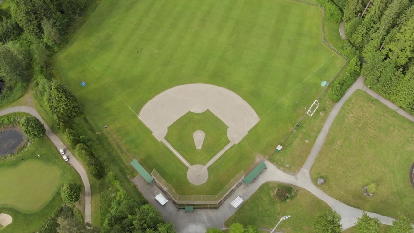 A top down aerial drone view of a green baseball field, baseball diamond, sports field, community park. 4K 24FPS. Royalty-Free Stock Footage #1093263731