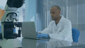 Animation of scientific data over afrcian american male lab worker using laptop. science, health, medicine and technology concept digitally generated video.
