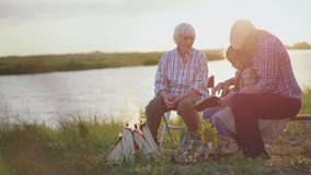Happy old caring grandparents read interesting book story lovely child granddaughter sitting at lake beach near bonfire at sunset outdoors. Peaceful family rest at nature, child adventure imagination - Powered by Shutterstock - Get 15% off with code: PIKWIZARD15