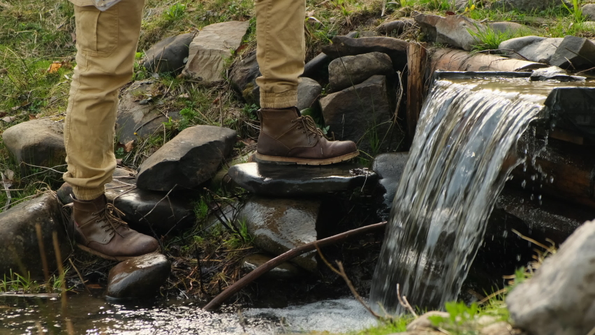 man drinking water from stream with her hands. male hands draw water from a mountain river. Hand of Thirsty Man taking water from drying river on summer metaphor water crisis and climate change