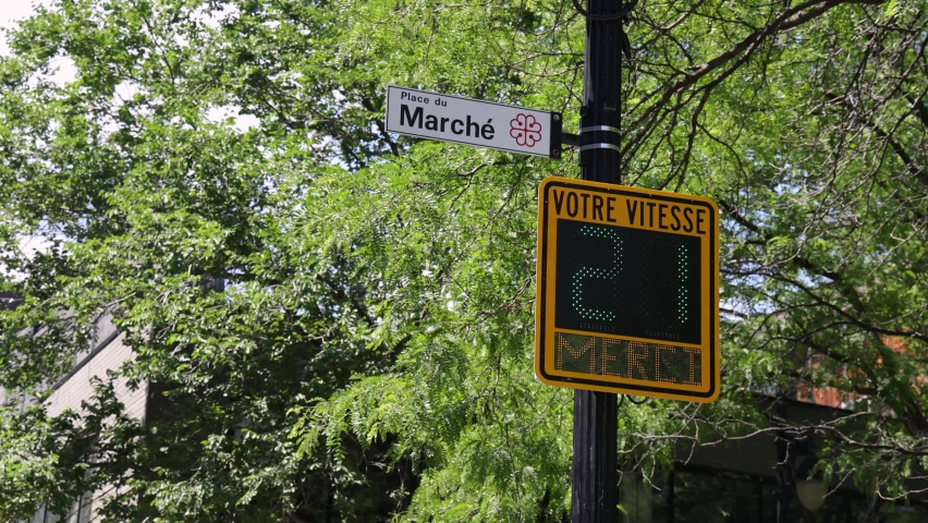 Closeup footage of a radar speed sign working on a street in Montreal, Canada. Numerical display showing speed of passing traffic against green trees. Royalty-Free Stock Footage #1093283801