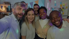 Portrait of excited businesspeople diverse group posing for camera during enjoyable office celebration at night. Photo and millennials concept.