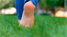 A child walks in the park on the grass with his feet. Selective focus. - Powered by Shutterstock - Get 15% off with code: PIKWIZARD15