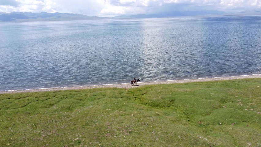 Mans ride on horses near to Song-Kul lake in Kyrgyzstan. Drone footage 4K. | Shutterstock HD Video #1093289209