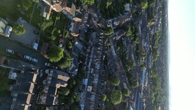 Vertical video aerial view of traditional UK terraced houses, river, suburbs and community.