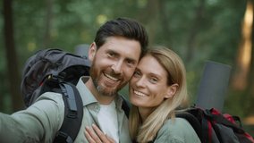 Capturing happy moments. Camera pov portrait of happy middle aged couple in love making selfie or recording funny video, making photos during hiking walk in forest, slow motion