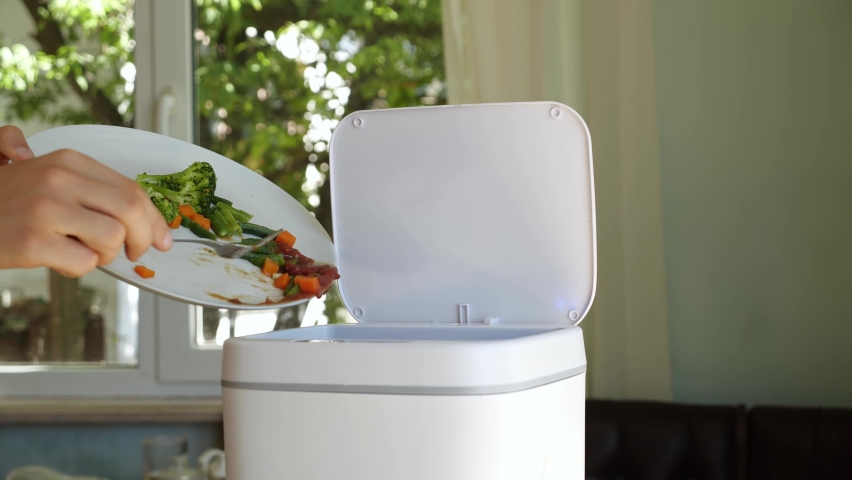 Throwing away uneaten food at home. Household Food Waste. Contactless Smart Touch Trash Can | Shutterstock HD Video #1093296991