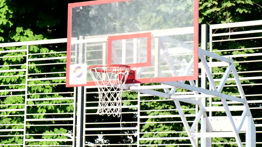 basketball ball going through hoop net outdoors close up