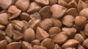 Close-up of raw buckwheat, close-up macro, selective focus. Slow rotation extreme macro high dynamic range. Vegan background