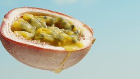 Passion fruit cut in half against a blue sky, dripping juice, close-up. - Powered by Shutterstock - Get 15% off with code: PIKWIZARD15