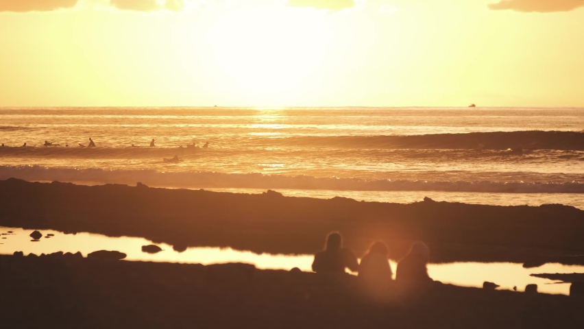 Best beautiful sunset or sunrise on paradise sand beach on the Canary island of Tenerife. Silhouettes of people on the beach are surfing on big waves. Playa de Las Americas on sunset. Go everywhere Royalty-Free Stock Footage #1093312219