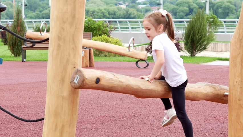 A little girl with two tails is having fun playing on a modern children