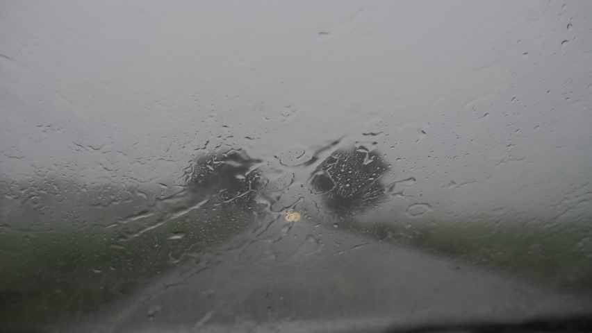 Rain drops on car windshield. View from inside a car. Driving in the rain. Storm on the road. Bad weather day on the road. | Shutterstock HD Video #1093316925