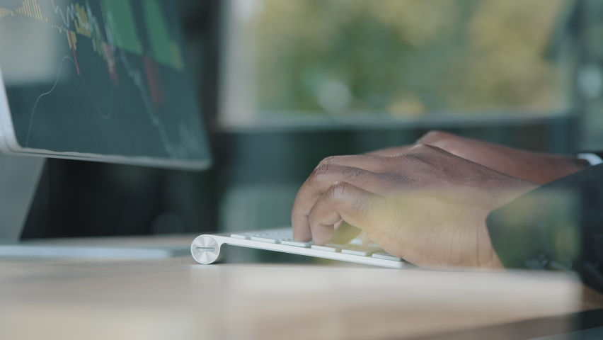 Close up behind glass view of unknown african businessman trader programmer IT specialist work on computer in monitoring control room typing on keyboard programming trading online developing - Powered by Shutterstock - Get 15% off with code: PIKWIZARD15