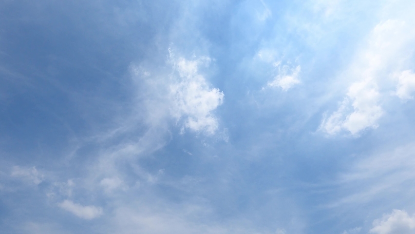Peaceful Backlit Time Lapse Clouds Against A Deep Blue Sky, Seamless Loop Of Clouds. Time-Lapse Motion Background.Wide Shot Of The Sun Shining In A Blue Sky As Fluffy Clouds Approach Sun With Cloud Royalty-Free Stock Footage #1093329547