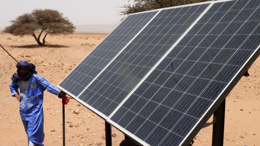 Solar energy panel in the Sahara desert, Erg Chigaga, Morocco. Newly built solar energy to get water from a well for the animals in the desert. 4k footage. Royalty-Free Stock Footage #1093330413