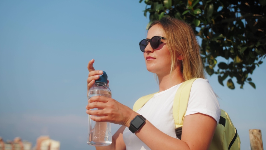 Woman drink water. Athletic female resting after workout summer day in park. Royalty-Free Stock Footage #1093334849