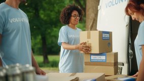 Happy Group of Volunteers Working on Delivering Humanitarian Aid and Donations, Loading Boxes into a Cargo Van. Successful Charity Workers High Five Each Other. - Powered by Shutterstock - Get 15% off with code: PIKWIZARD15