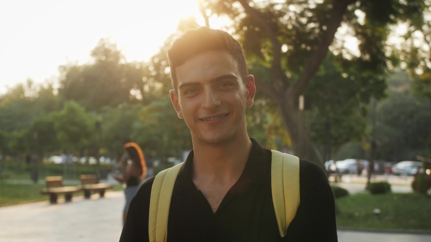 Portrait of a happy young tourist man posing for camera. Handsome multiethnic male charmingly smiling.