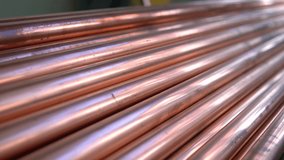 Metal, copper pipes stack with shiny reflections at warehouse. Plumbing, round tube sewerage products, manufacturing for building and construction, business production. Close up pan. - Powered by Shutterstock - Get 15% off with code: PIKWIZARD15