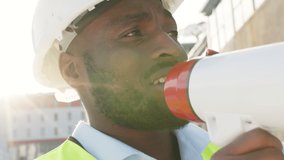 Building manager with megaphone talking, explaining and instructing construction workers, architects and engineers. Closeup headshot or infrastructure leader face motivating staff on development - Powered by Shutterstock - Get 15% off with code: PIKWIZARD15