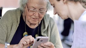 The smartphone is in the hands of a grandmother who communicates online with friends.