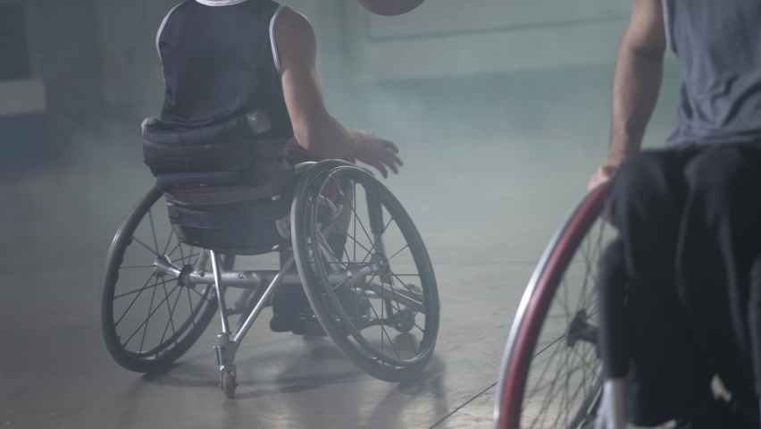 Two disabled athletes playing basketball. athlete in wheelchair passes ball to team member Royalty-Free Stock Footage #1093369495