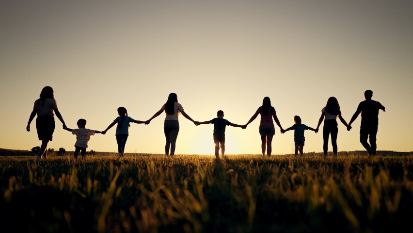Happy family. Silhouette of large group of people at picnic in park. The family generation walks on the green grass. Parents and children play in nature. Family walking together across field at Royalty-Free Stock Footage #1093369669