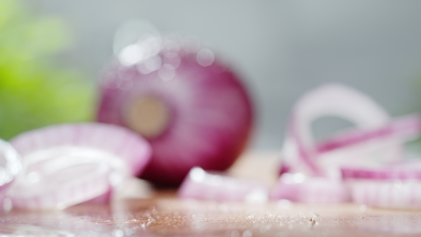 Purple Onion Rings Thrown onto a Wet Wooden Cutting Board Rolling and Bouncing in Slow Motion 1000fps