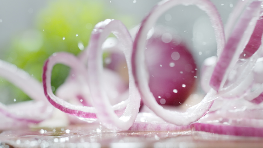 Purple Onion Rings Thrown onto a Wet Wooden Cutting Board Rolling and Bouncing in Slow Motion 1000fps