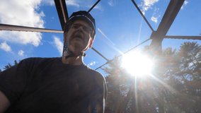 60-Year-old man walking his bike over an old bridge. High-quality 4k footage shot on a sunny day on a rails to trails bike path. Older active lifestyle clip 