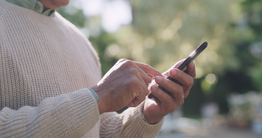 Senior man standing, smiling and texting his friends or family outside. Happy old guy using technology, connected and independent on social media. Finding companionship and staying connected online. | Shutterstock HD Video #1093375159
