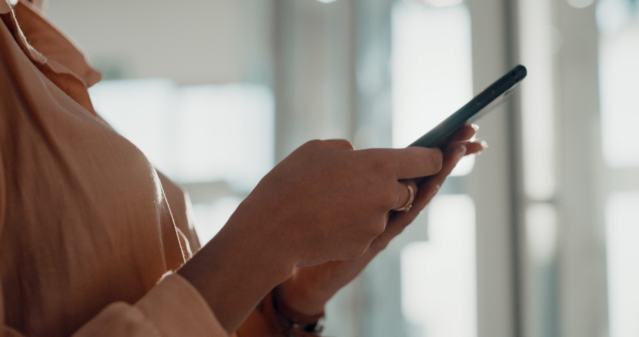 A marketing, communication and texting businesswoman using phone to send a message, email, or text online. Professional hands typing on internet or social media app with bokeh background and closeup