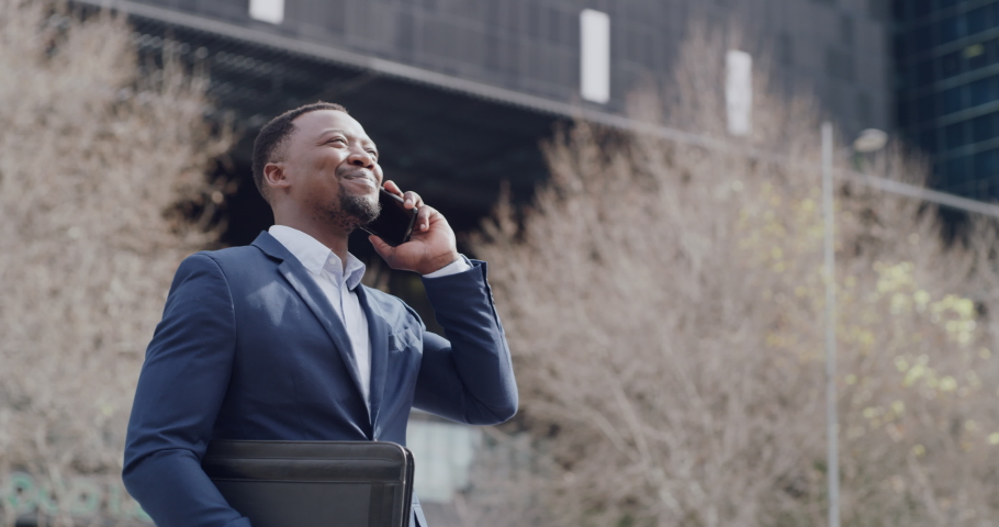 Stylish and successful businessman talking on a phone call, laughing while networking on a cellphone alone in the city. Young entrepreneur, investor or startup owner chatting before meeting a client | Shutterstock HD Video #1093375309