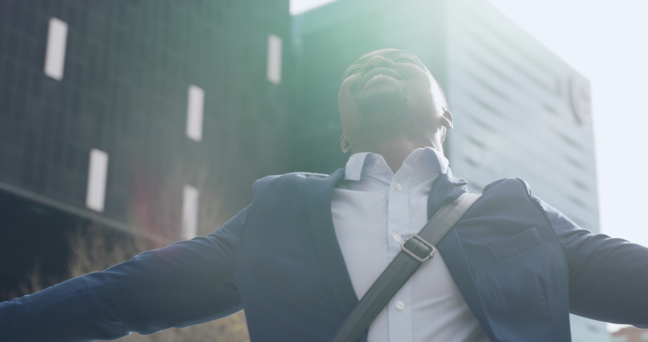 Happy, carefree and freedom feeling of a city business man enjoying the morning sun outside. Corporate worker with a positive mindset and open arms ready to start the day with happiness and success | Shutterstock HD Video #1093375315