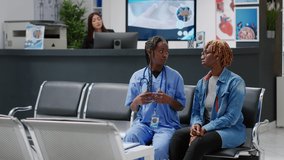 African american nurse and patient using medical hologram to analyze AI holographic metaverse projection in waiting room. People looking at artificial intelligence augmented reality. Tripod shot. - Powered by Shutterstock - Get 15% off with code: PIKWIZARD15