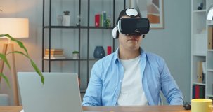 Asian man wearing virtual reality headset. Augmented Reality. Creative man touch something using modern 3D vr glasses.