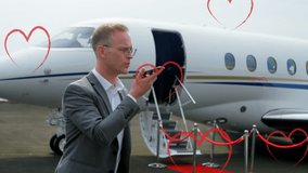 Animation of heart icons over caucasian businessman using smartphone. Global business and digital interface concept digitally generated video. - Powered by Shutterstock - Get 15% off with code: PIKWIZARD15